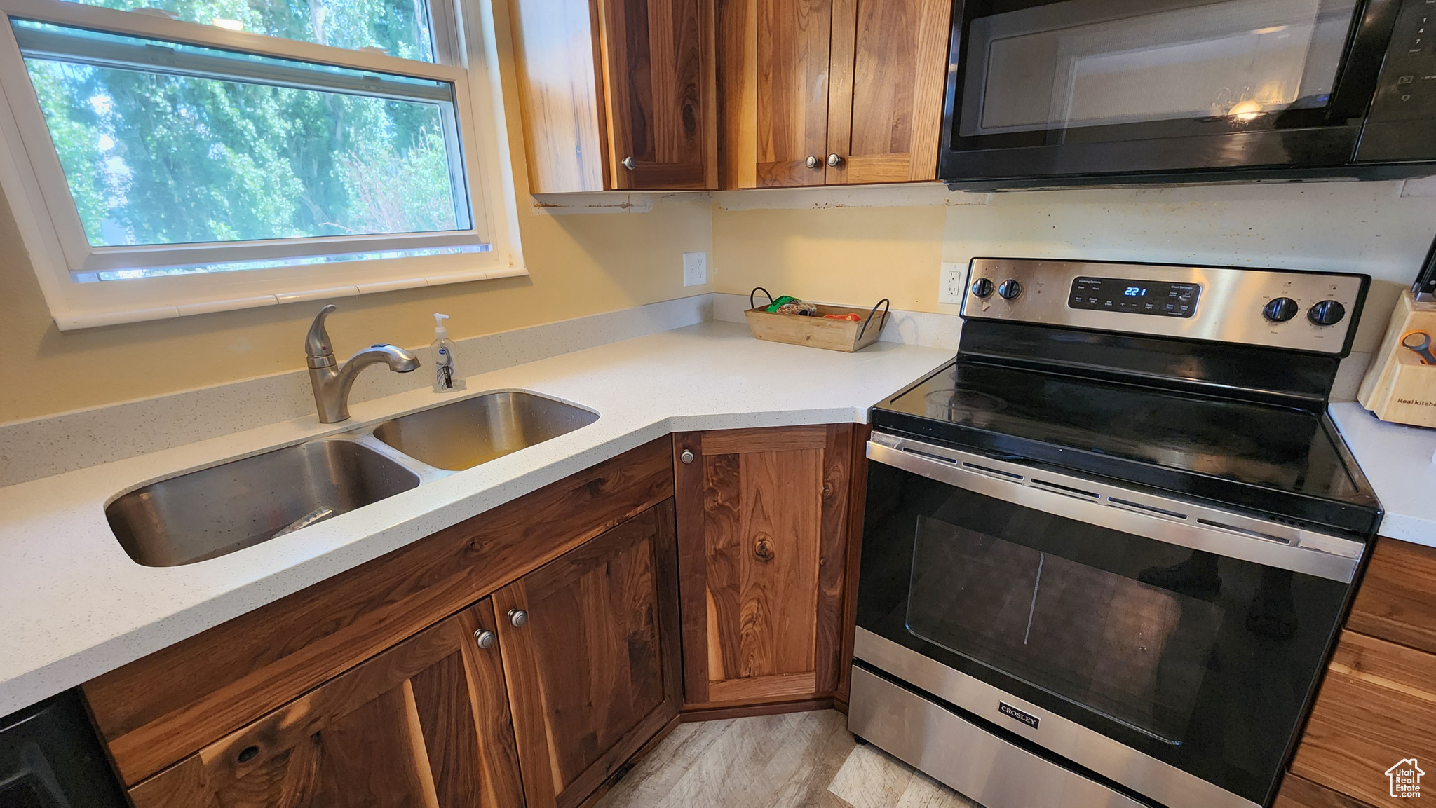 Kitchen featuring stainless steel range with electric cooktop, sink, and a wealth of natural light