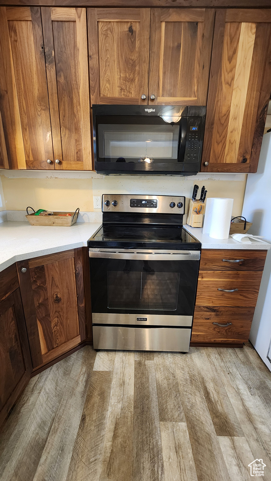 Kitchen featuring light wood-type flooring and stainless steel electric range oven