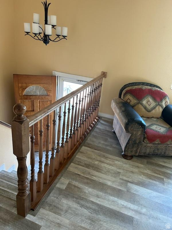 Stairs featuring wood-type flooring and a chandelier