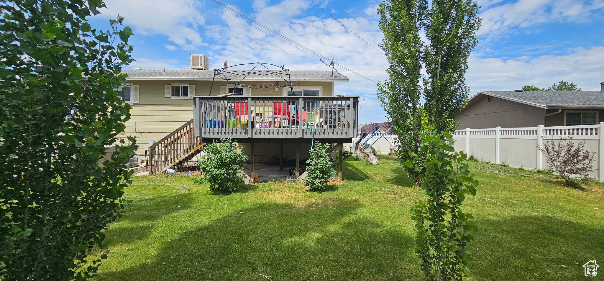 Rear view of house with a deck and a yard