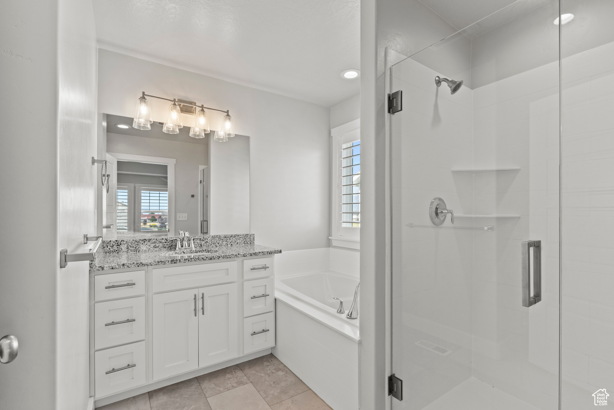 Bathroom featuring vanity and independent shower and bath