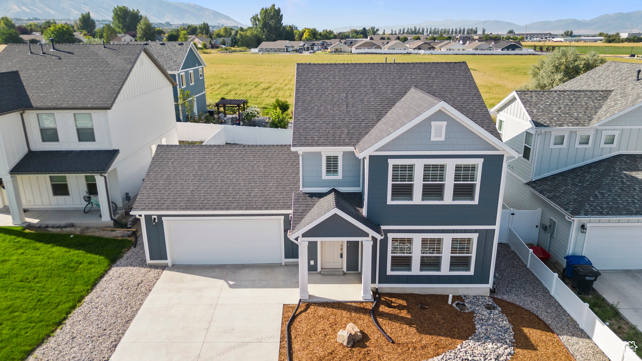 View of front of home with a front lawn, a garage, and a mountain view