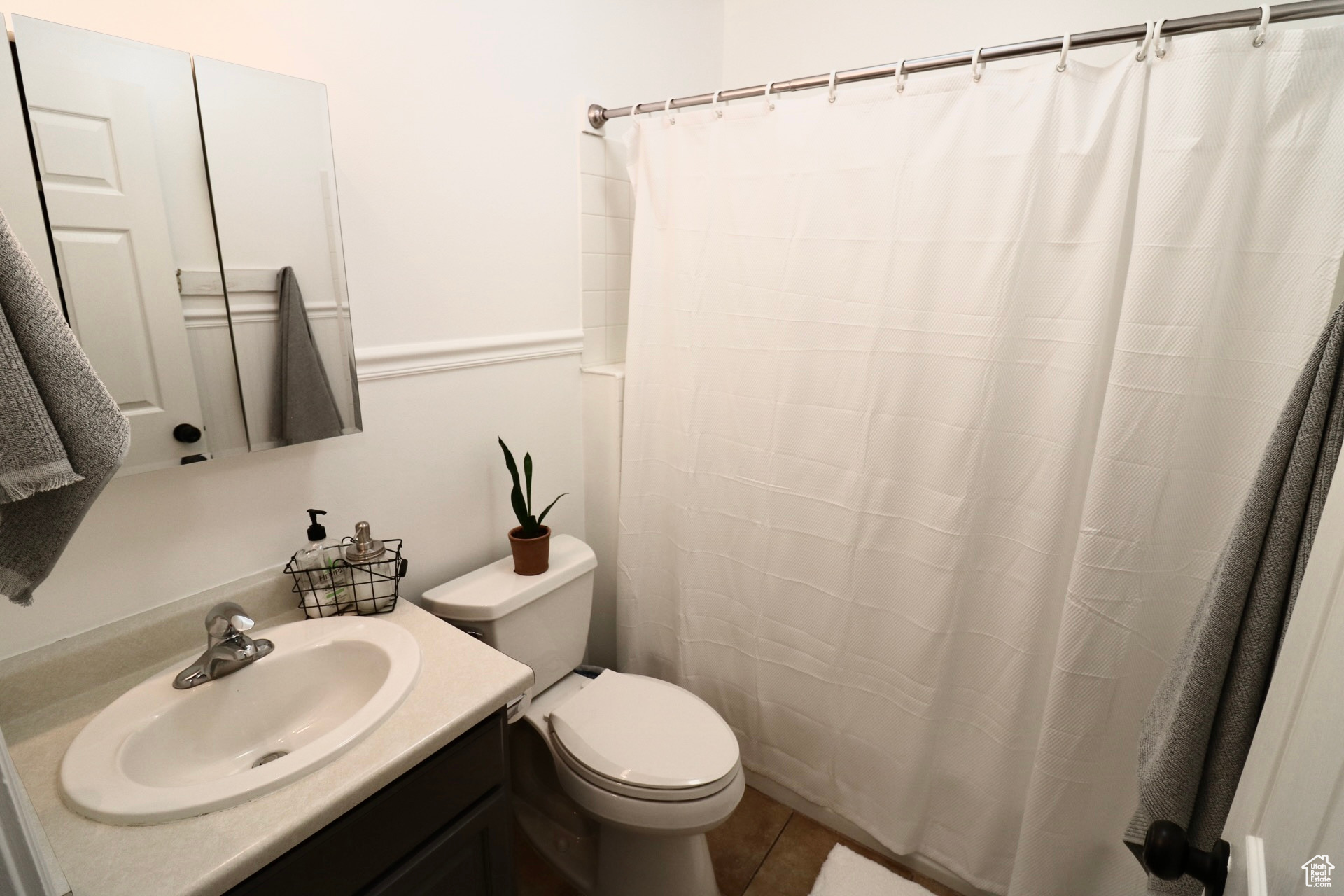 Bathroom featuring vanity, toilet, and tile floors