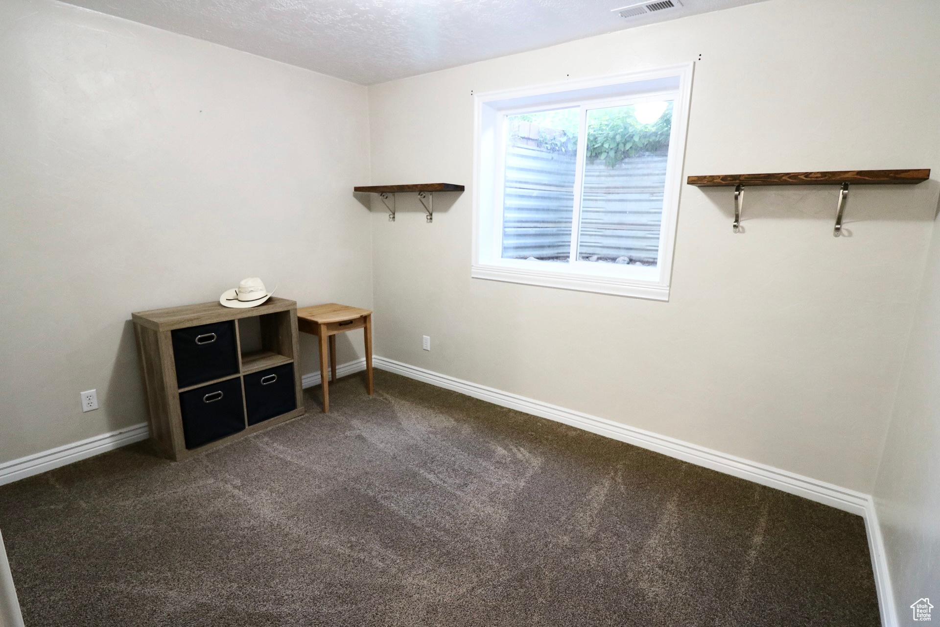 Misc room featuring a textured ceiling and carpet floors