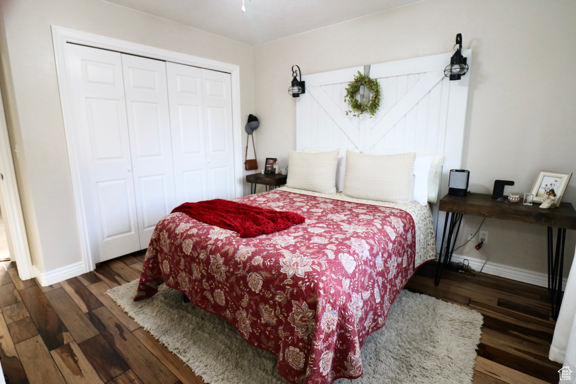 Bedroom with dark hardwood / wood-style floors and a closet