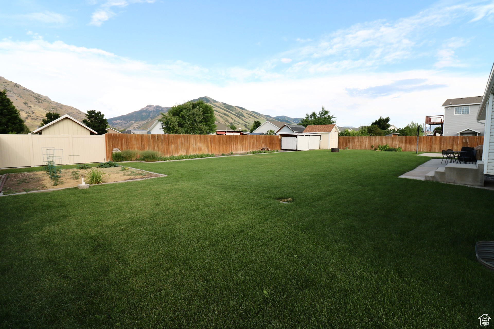 View of yard featuring a patio, a storage shed, and a mountain view