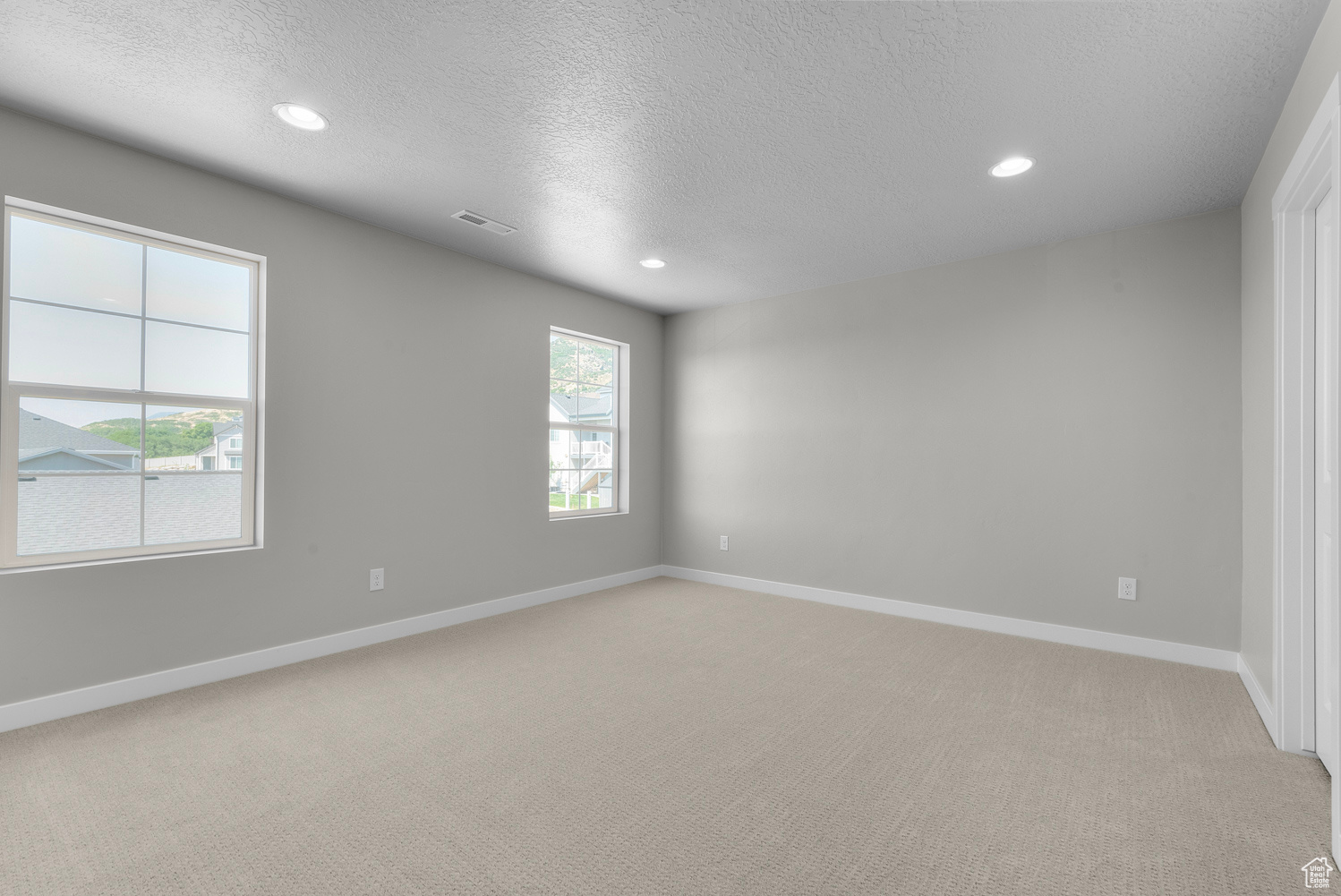 Carpeted spare room featuring a textured ceiling