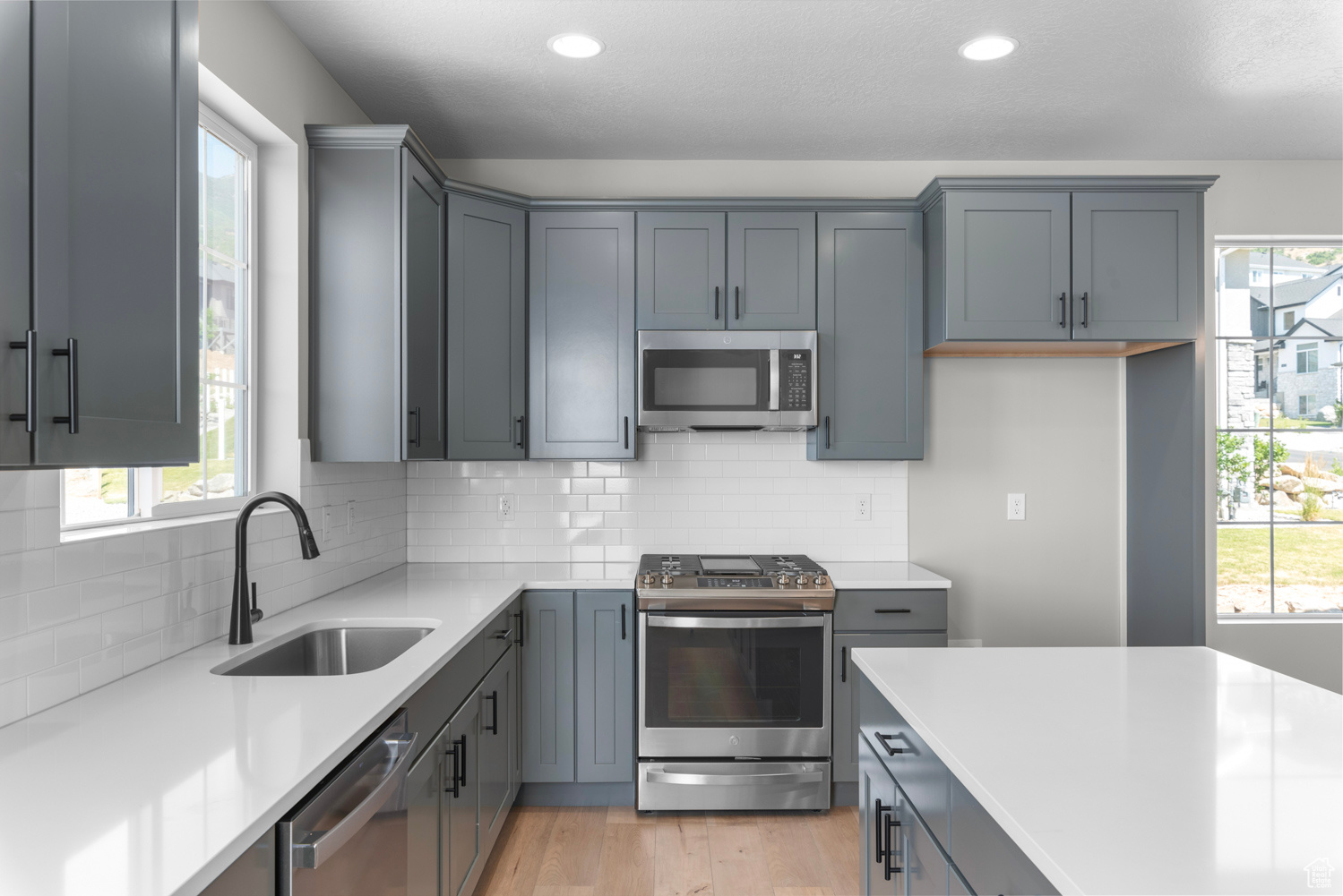 Kitchen with sink, a healthy amount of sunlight, light wood-type flooring, and stainless steel appliances