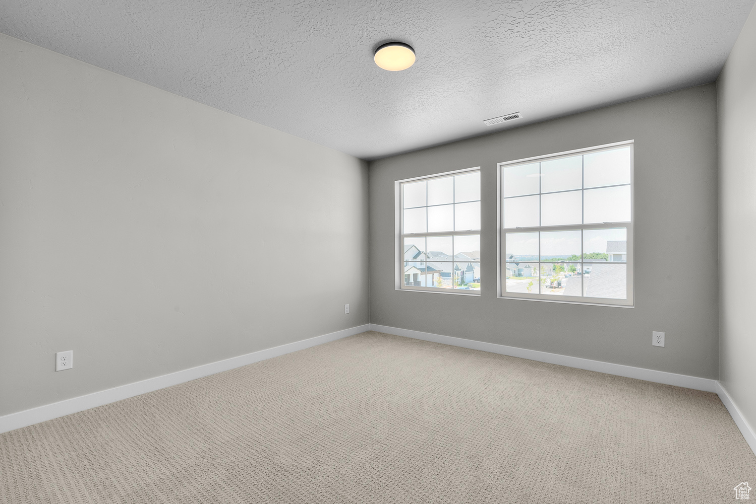 Carpeted spare room featuring a textured ceiling