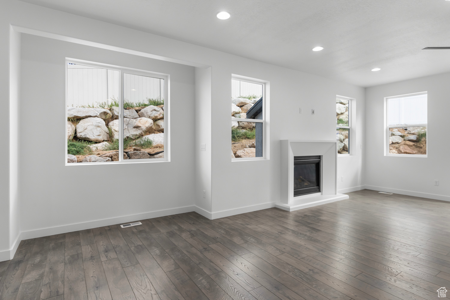 Unfurnished living room featuring dark hardwood / wood-style floors