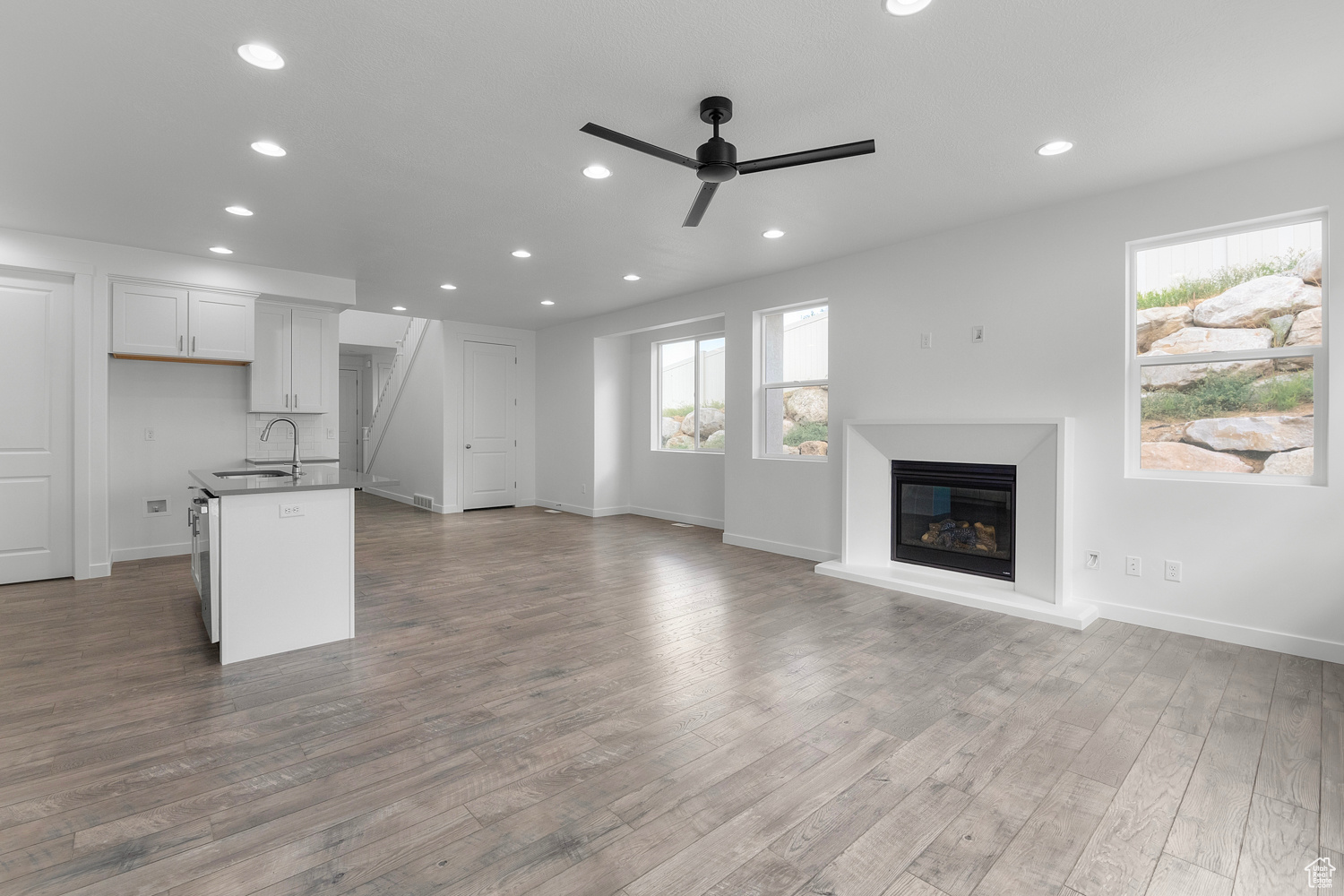 Interior space with ceiling fan, sink, and light wood-type flooring