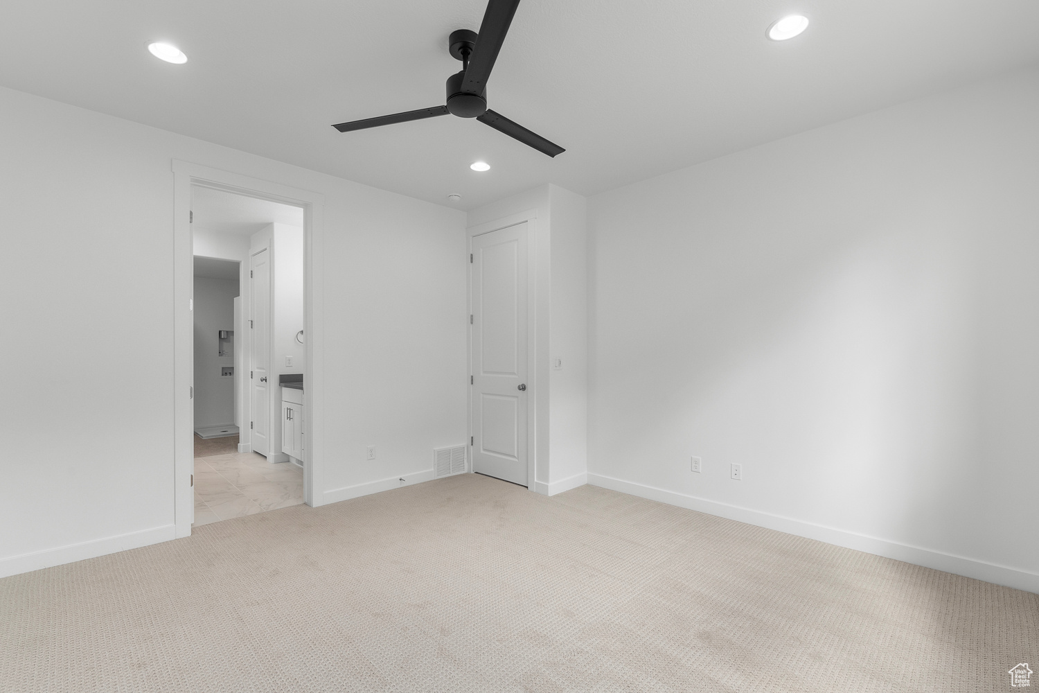 Carpeted empty room featuring ceiling fan