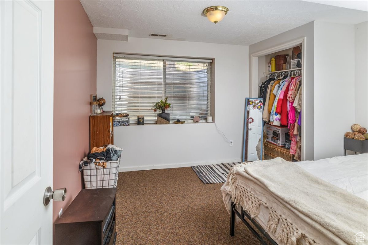 Bedroom 4 with carpet, a closet, and a textured ceiling