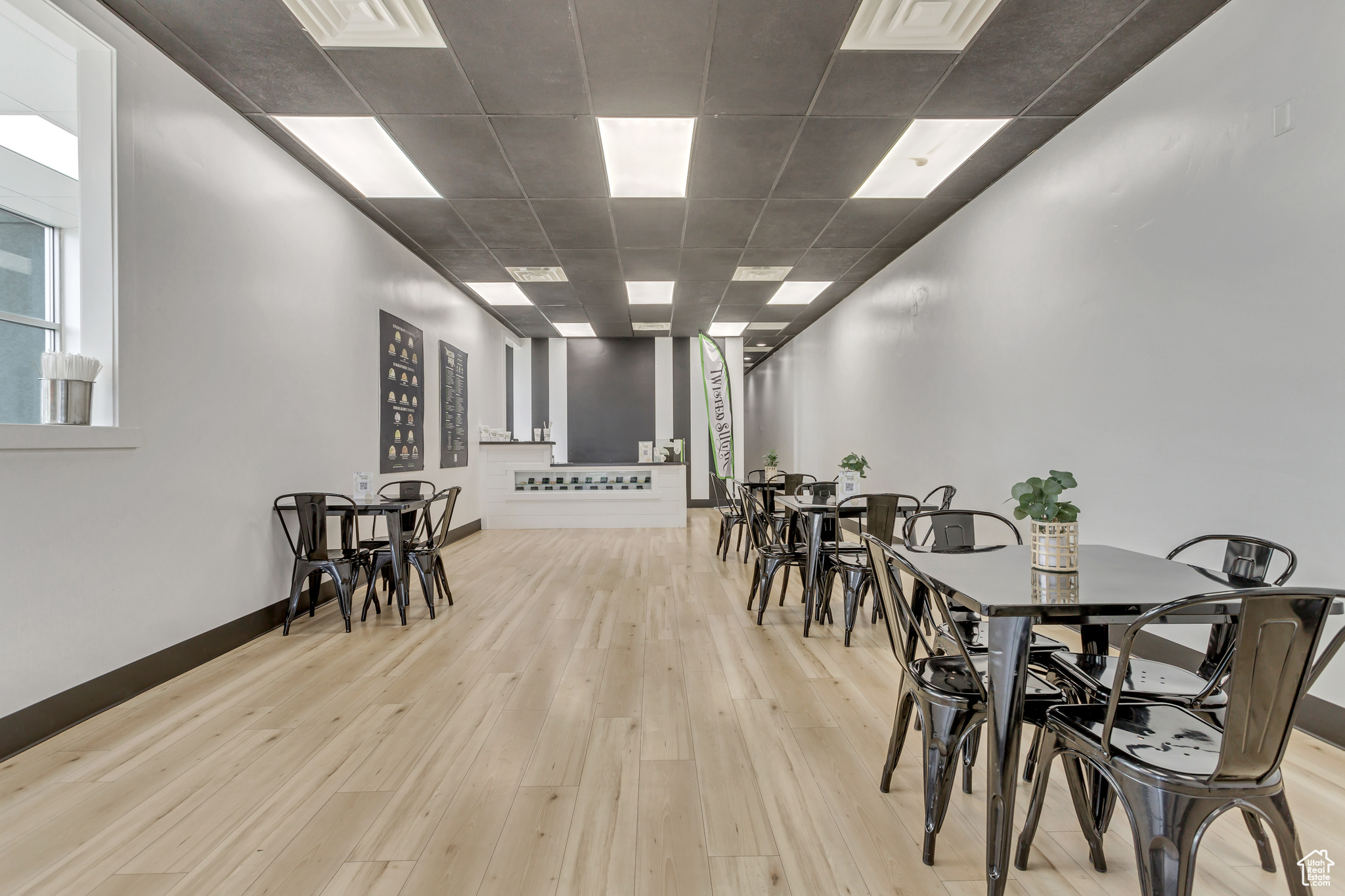 Dining area with light wood-type flooring and a drop ceiling