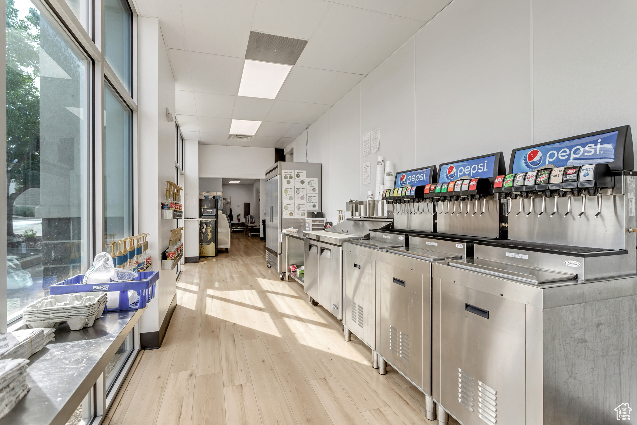 Kitchen with stainless steel counters, light wood-type flooring, and a drop ceiling