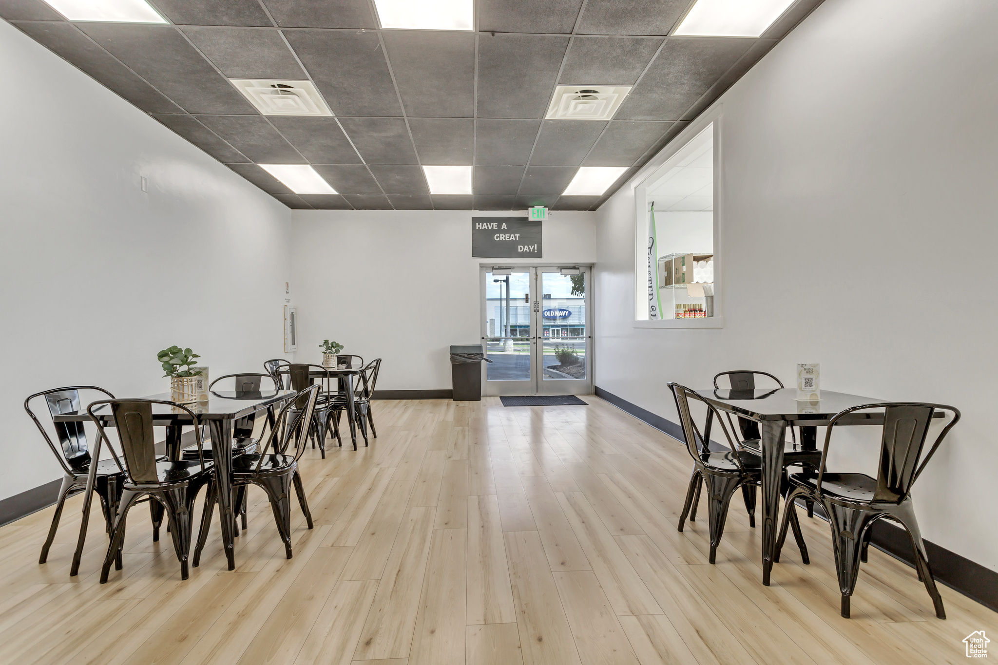 Dining room featuring light hardwood / wood-style flooring, french doors, and a drop ceiling