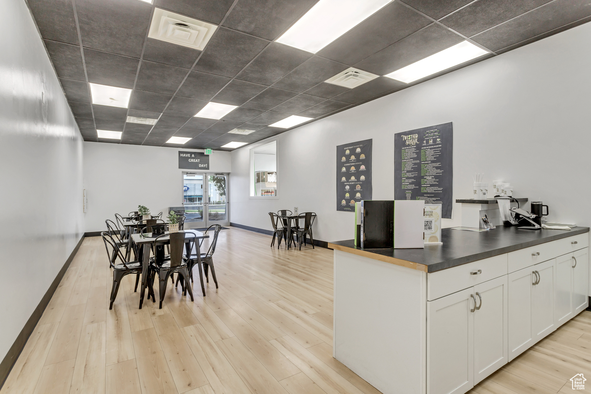 Kitchen featuring white cabinetry, light wood-type flooring, and a drop ceiling