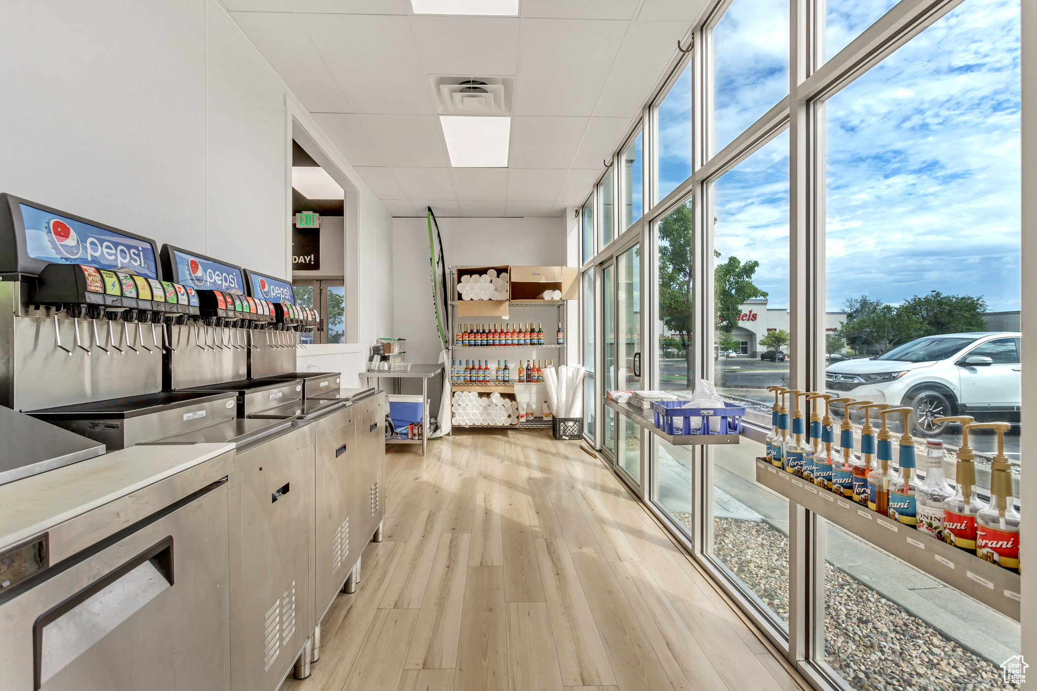 Kitchen with floor to ceiling windows, white cabinetry, and light hardwood / wood-style floors