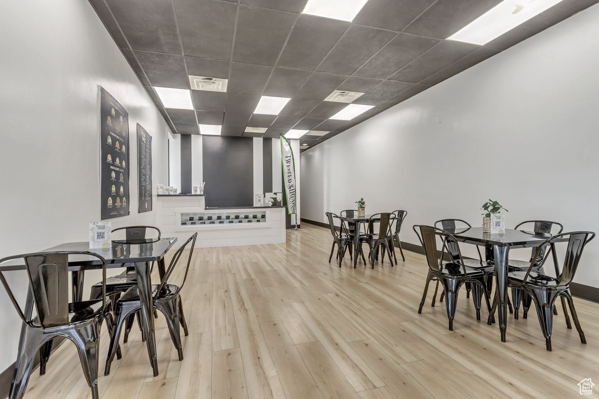 Dining space with light wood-type flooring and a drop ceiling