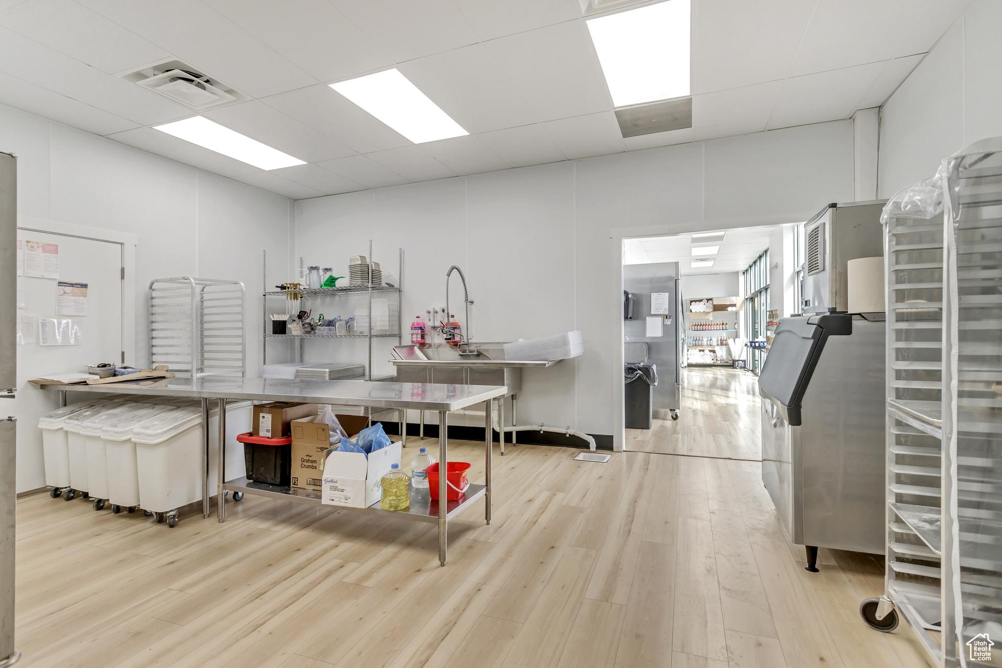 Kitchen featuring a paneled ceiling, light hardwood / wood-style floors, and kitchen peninsula