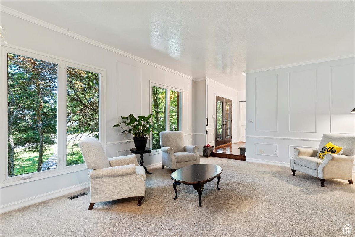 Sitting room featuring ornamental molding, carpet flooring, and french doors