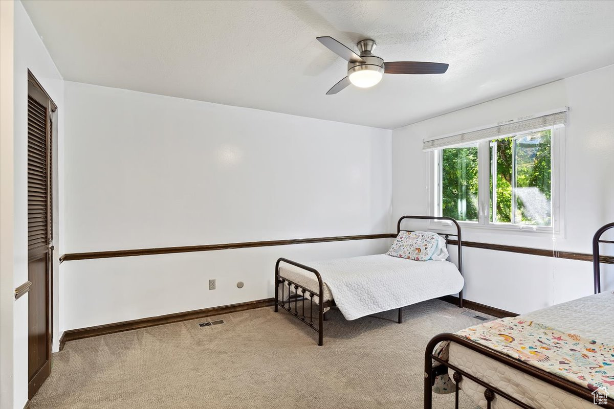 Carpeted bedroom with ceiling fan