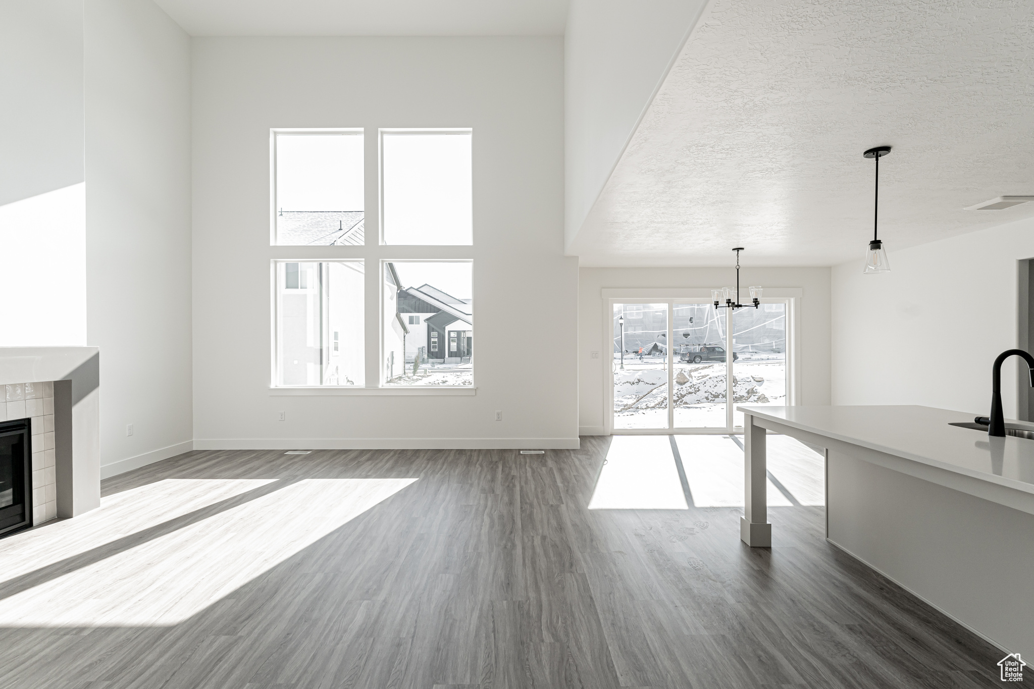 Unfurnished living room with sink, a fireplace, dark hardwood / wood-style floors, and a textured ceiling