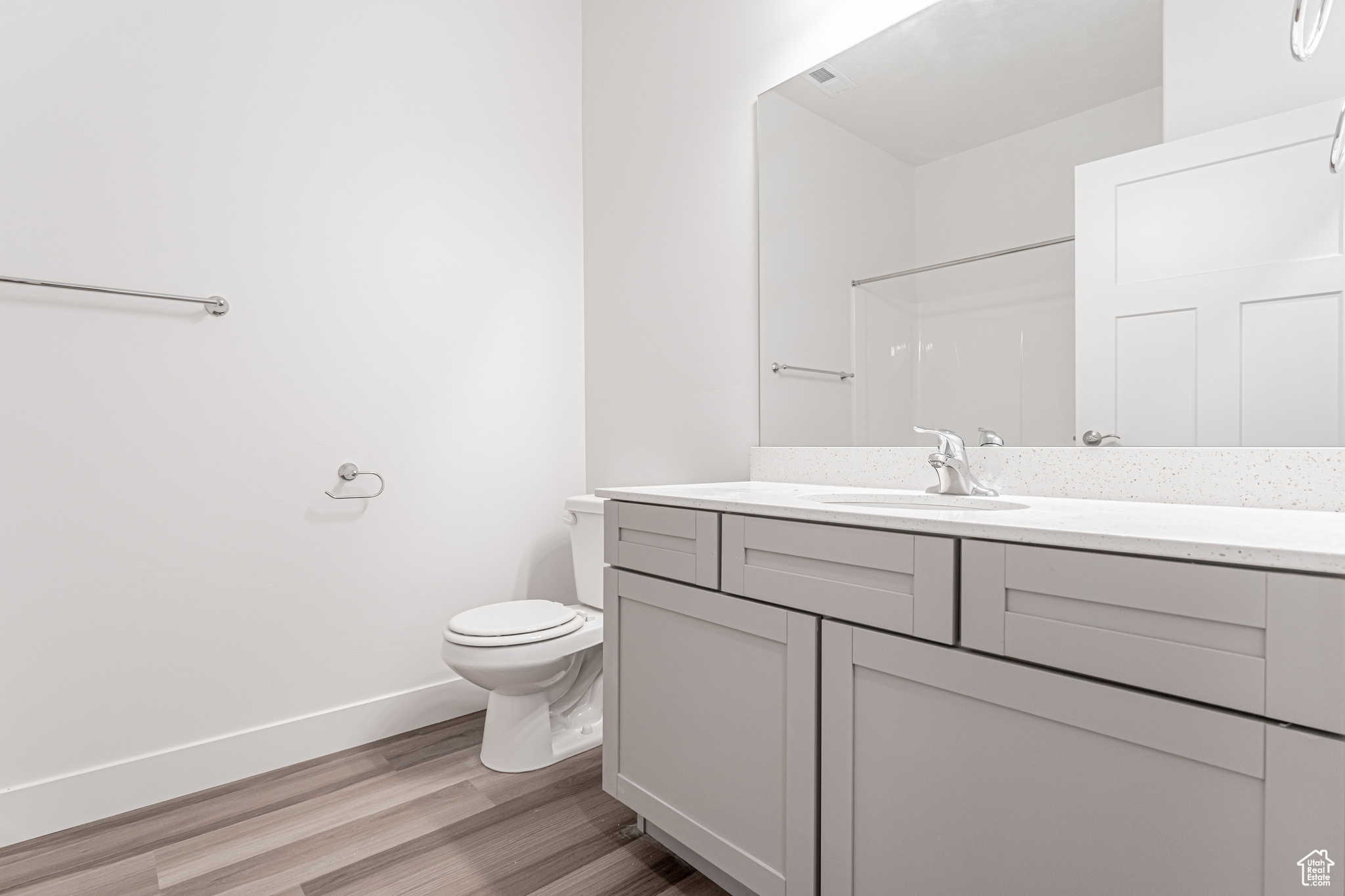 Bathroom featuring a shower, vanity, hardwood / wood-style flooring, and toilet