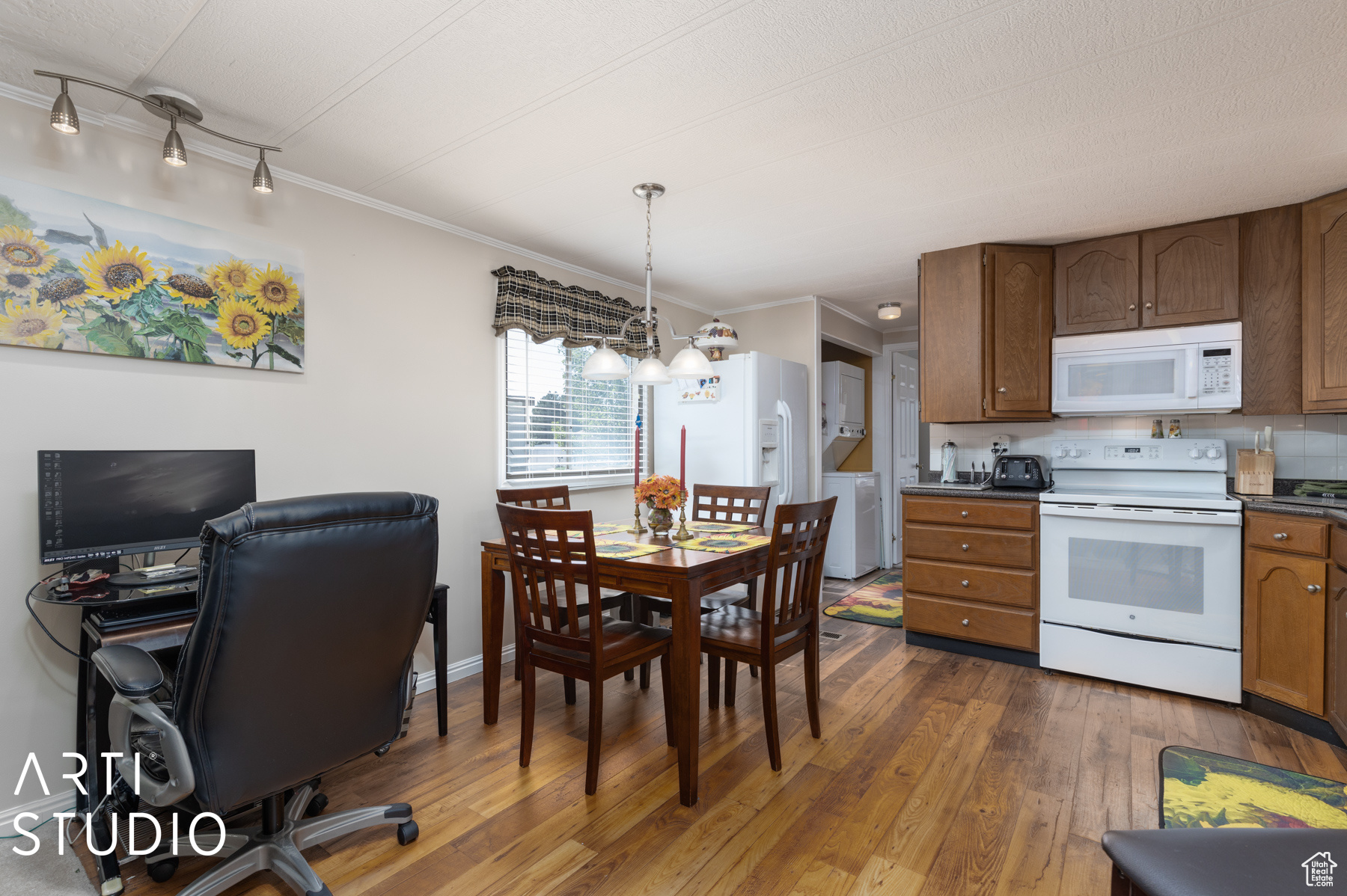 Kitchen with a chandelier, dark hardwood / wood-style flooring, white appliances, ornamental molding, and track lighting