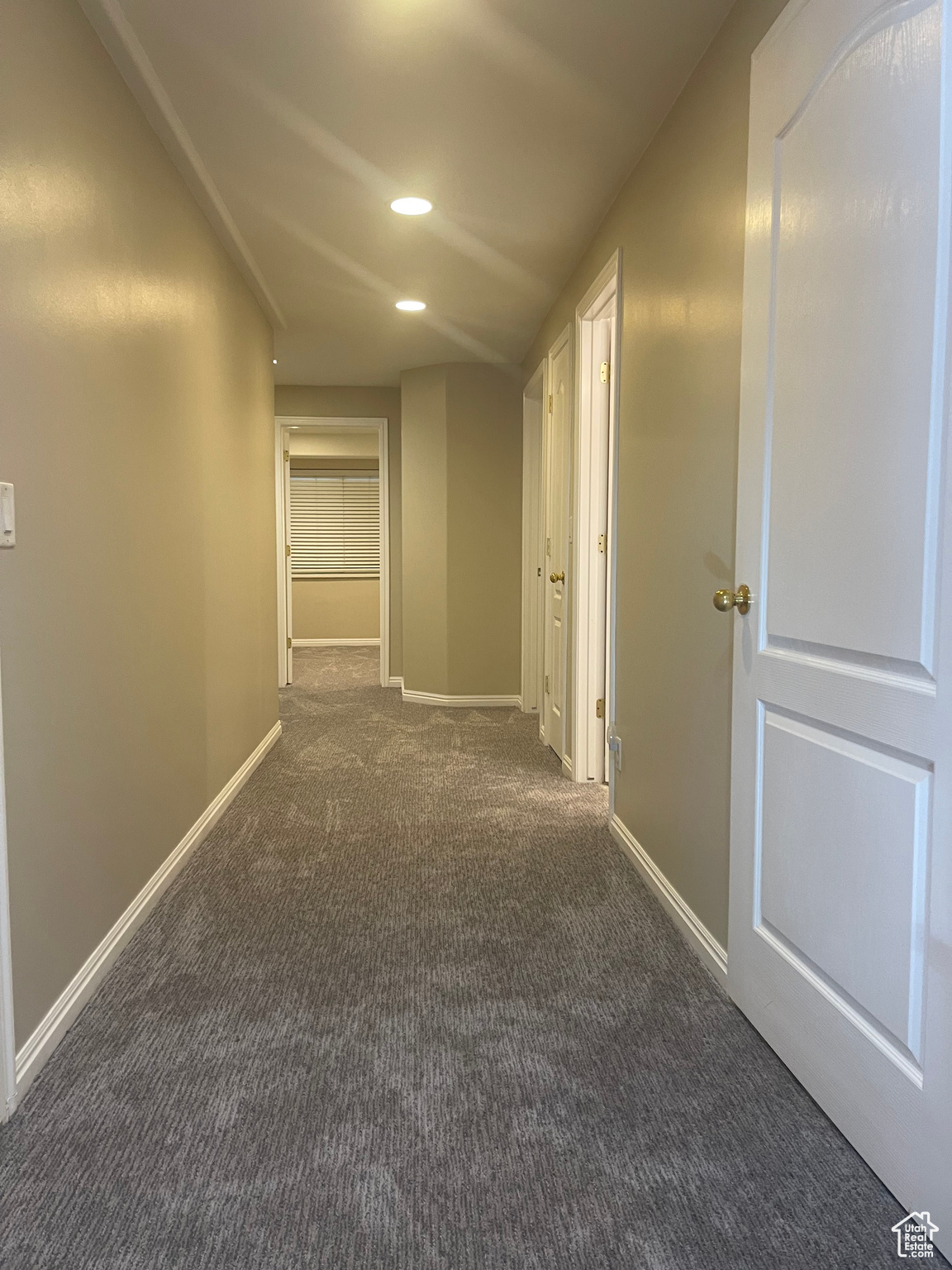 Hallway featuring dark carpet