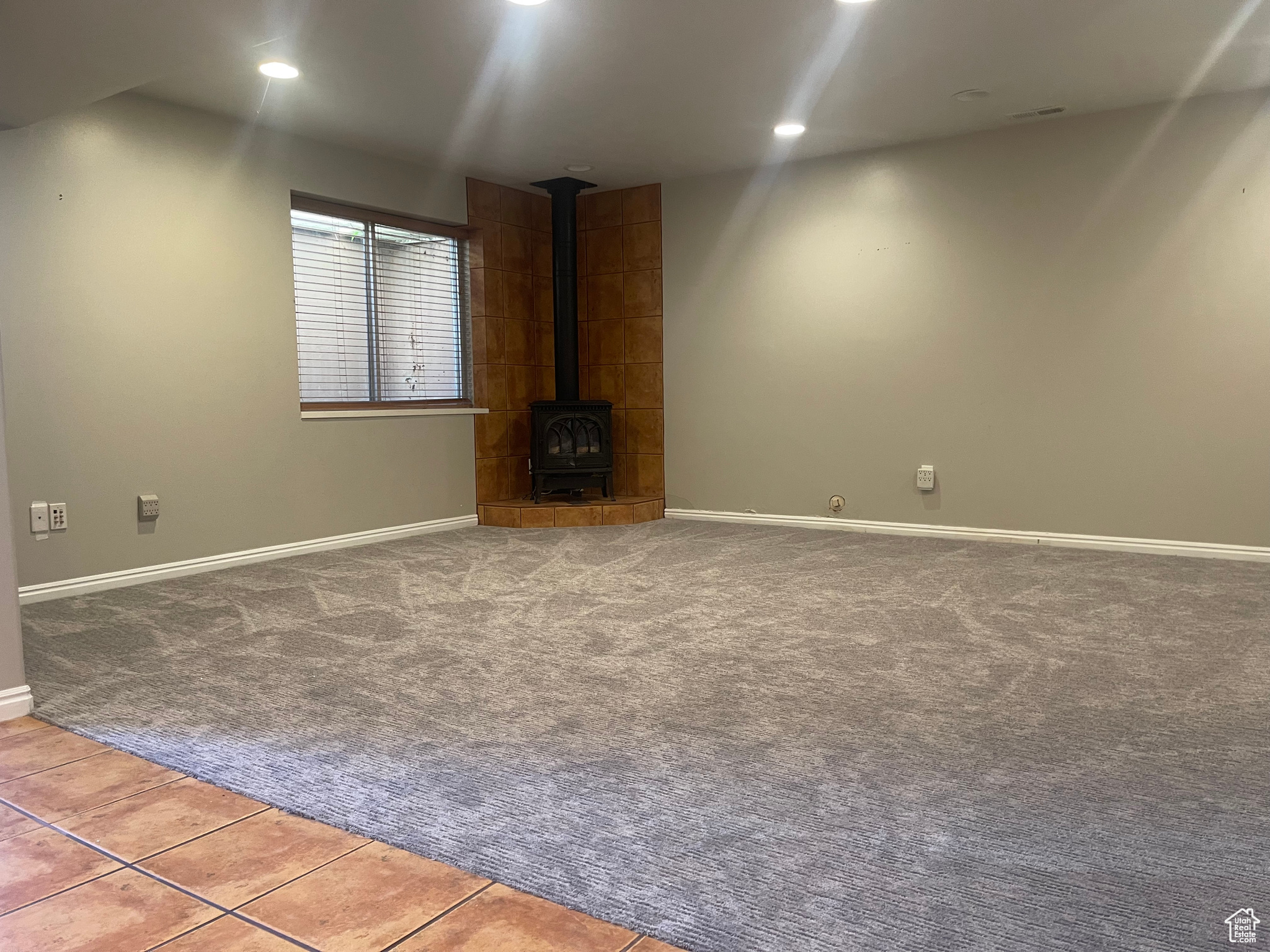 Large Primary Bedroom with a wood stove and carpet flooring