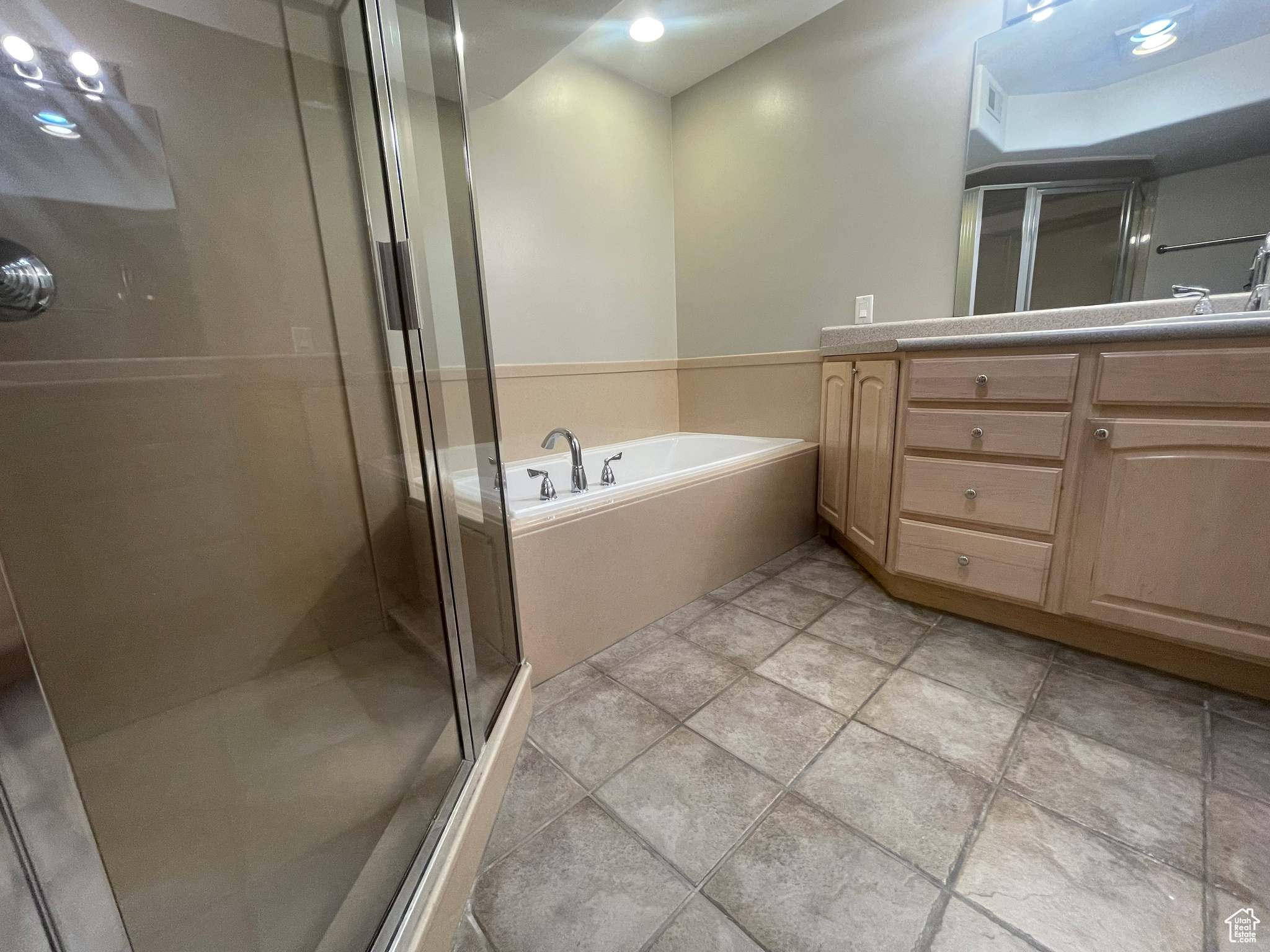 Primary Bathroom featuring dual vanity, tile patterned floors, and plus walk in shower