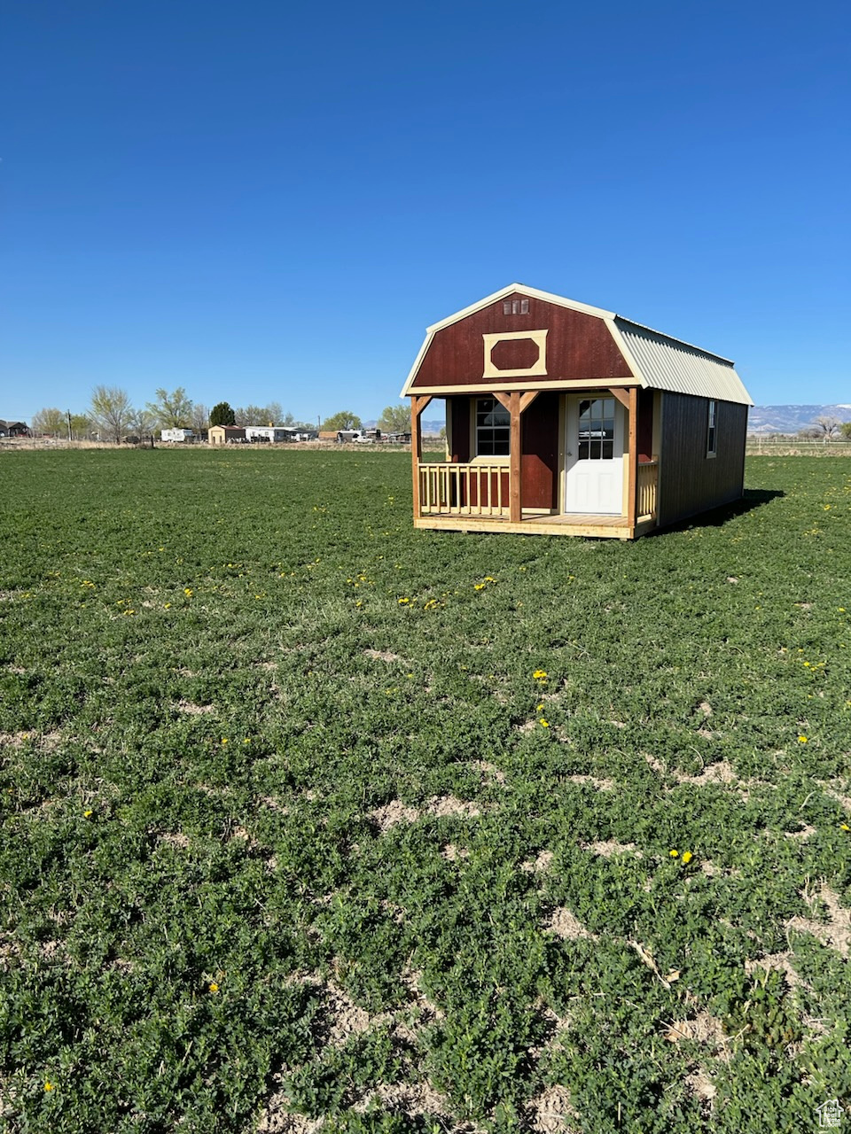 View of outdoor structure with a lawn and a rural view