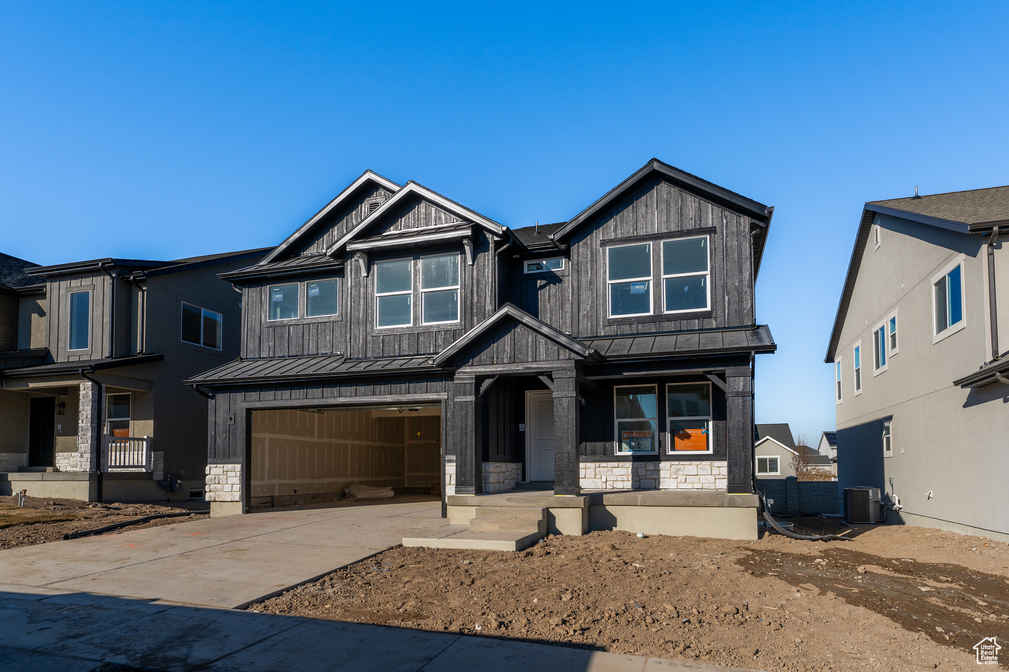 View of front of property featuring a garage and central AC