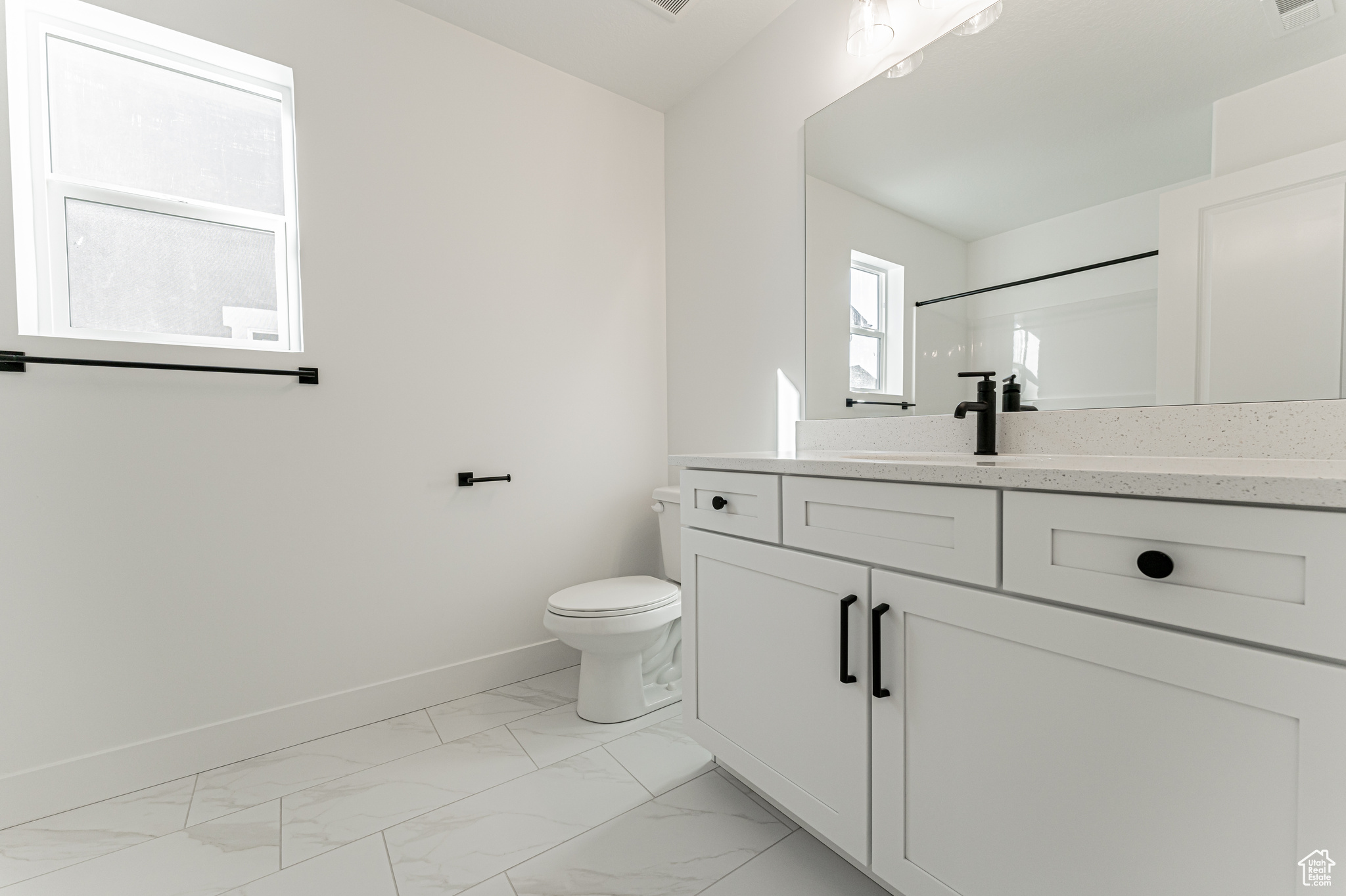 Bathroom with vanity, toilet, and a shower