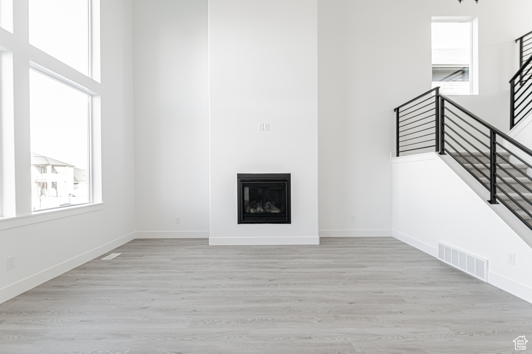 Unfurnished living room with a high ceiling and light hardwood / wood-style flooring