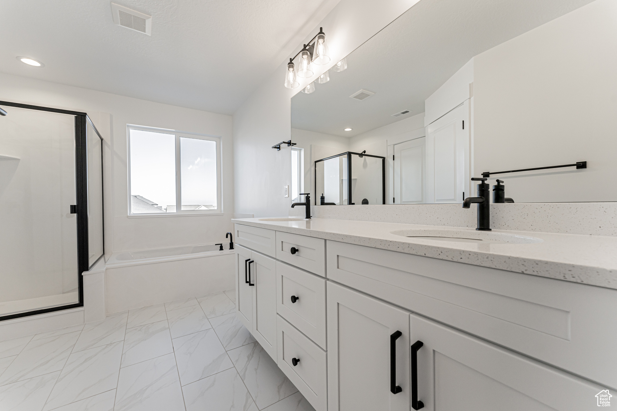 Bathroom featuring vanity and separate shower and tub