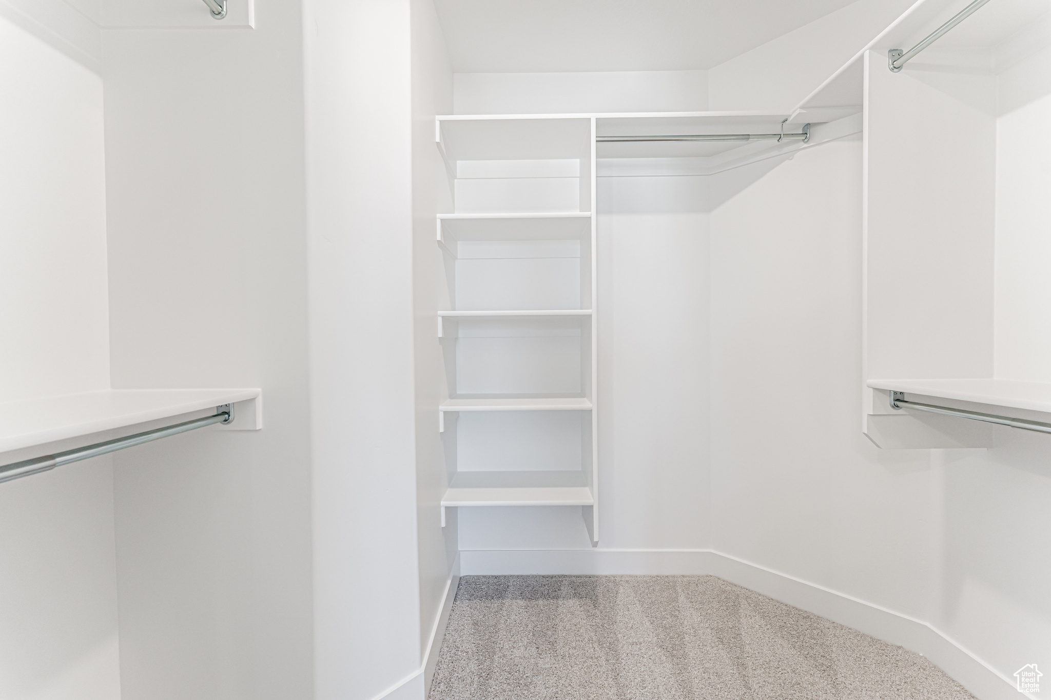 Walk in closet with light colored carpet