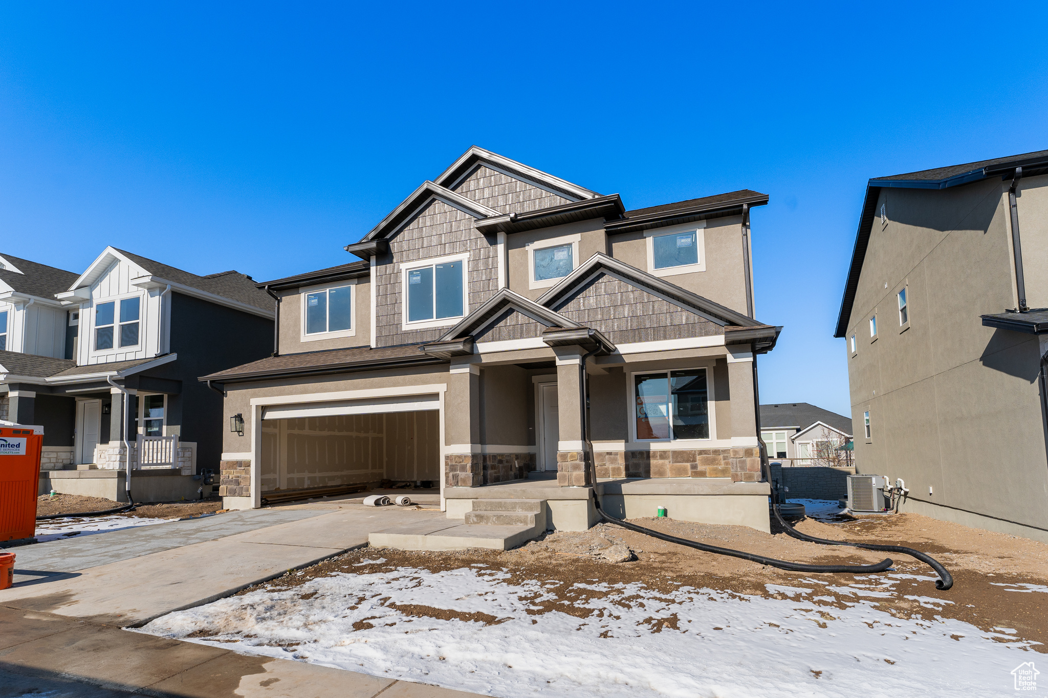 View of front of property featuring a garage and central air condition unit