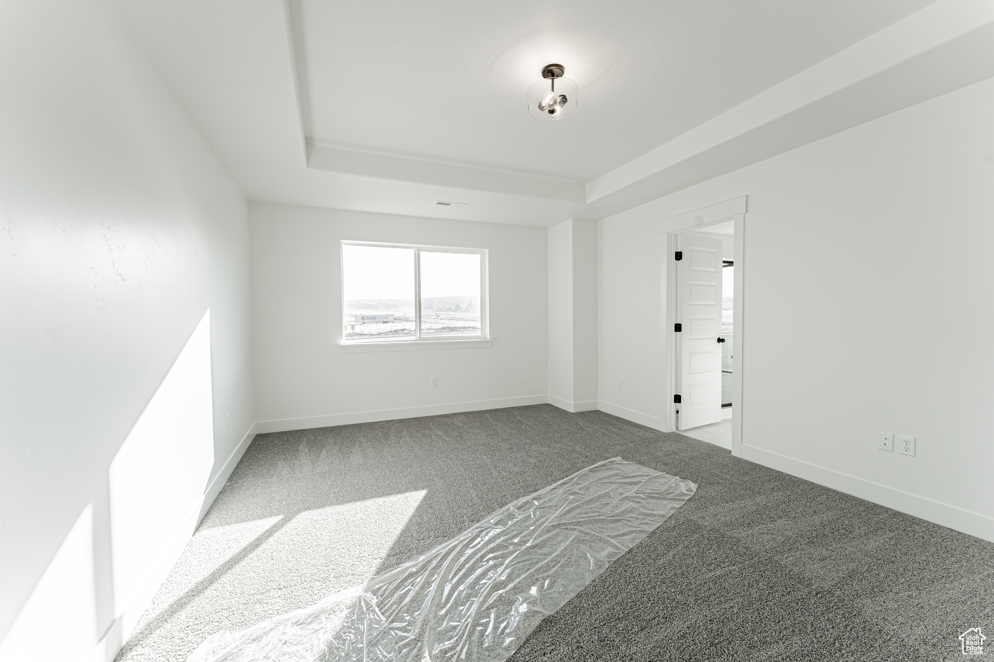 Carpeted empty room with a tray ceiling