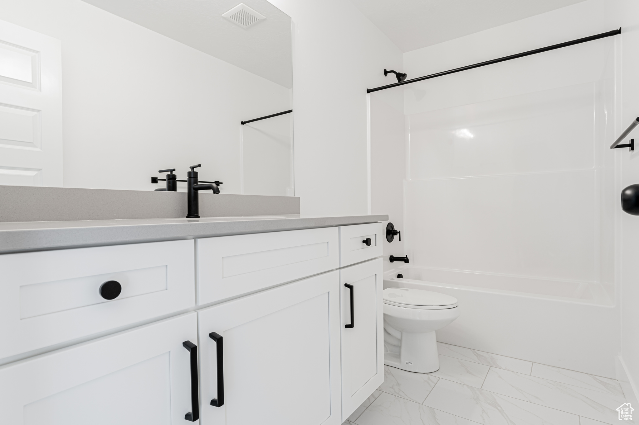 Full bathroom featuring toilet, vanity, and shower / bath combination