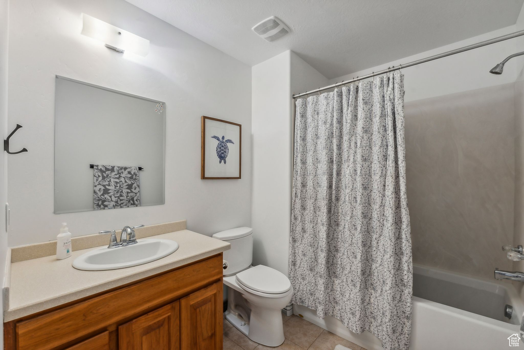 Full bathroom featuring vanity, toilet, tile patterned floors, and shower / bathtub combination with curtain