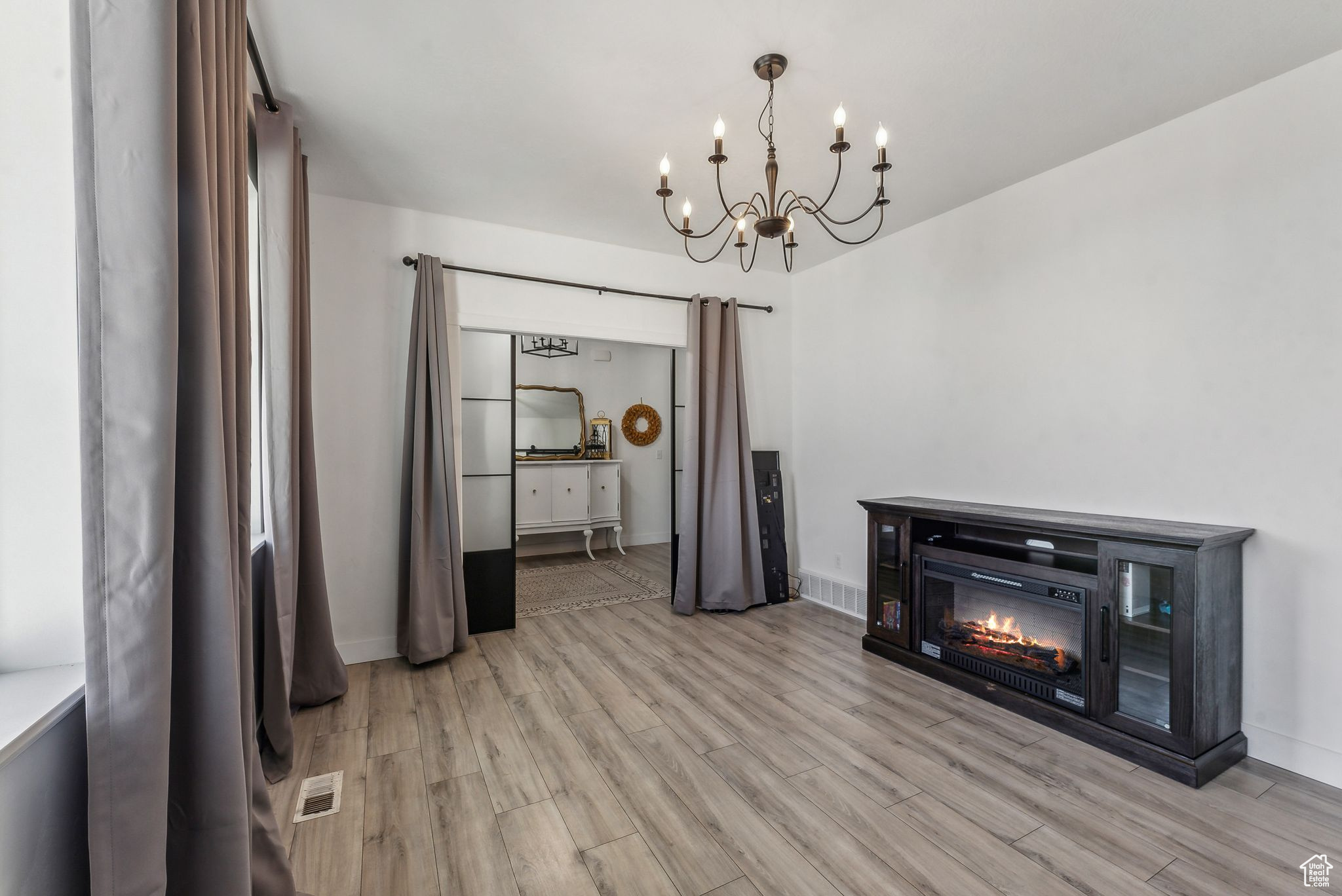 Unfurnished dining area with a notable chandelier and light hardwood / wood-style flooring