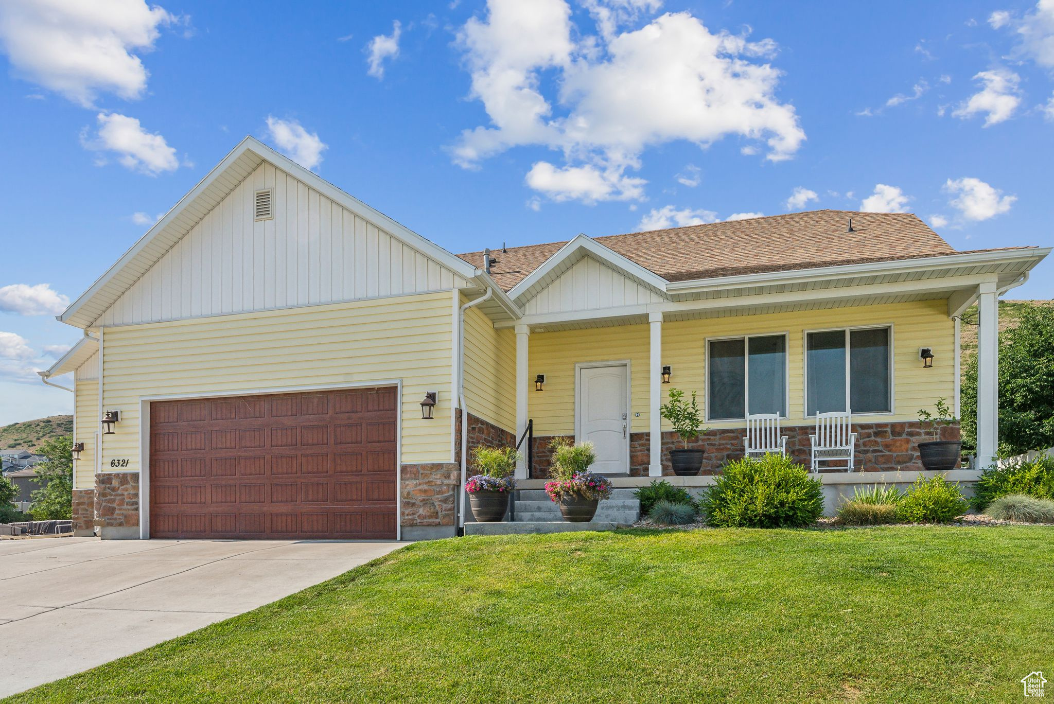 View of front of home featuring a porch, a garage, and a front yard