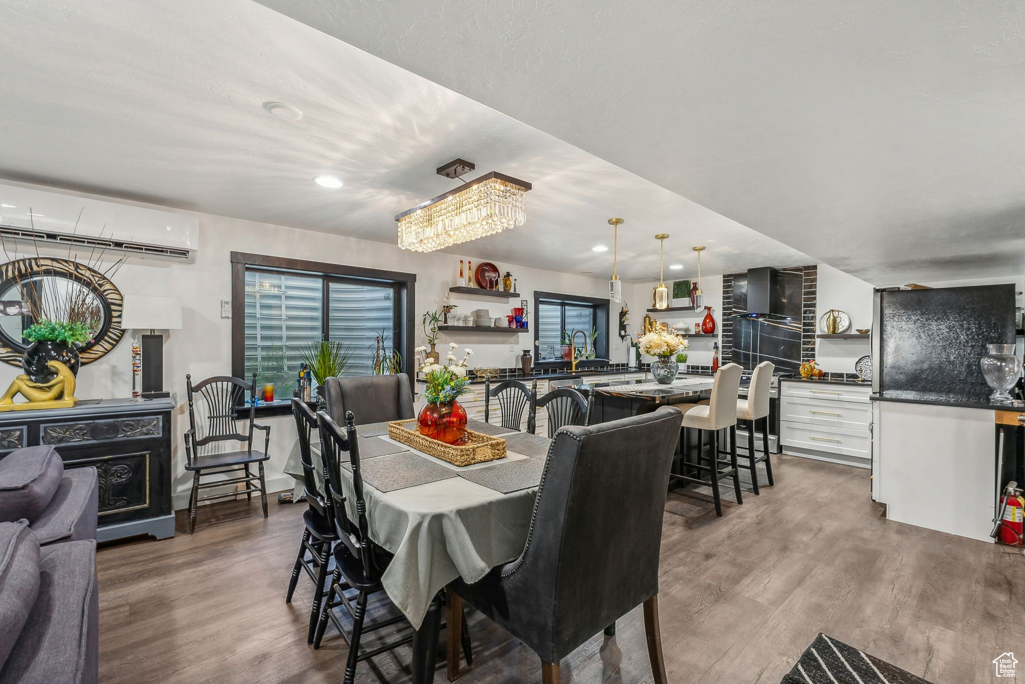 Dining space with a wall mounted air conditioner and dark hardwood / wood-style floors