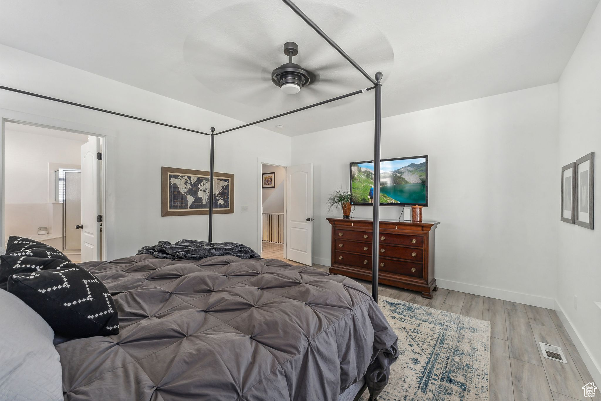 Bedroom featuring light wood-type flooring, ensuite bath, and ceiling fan