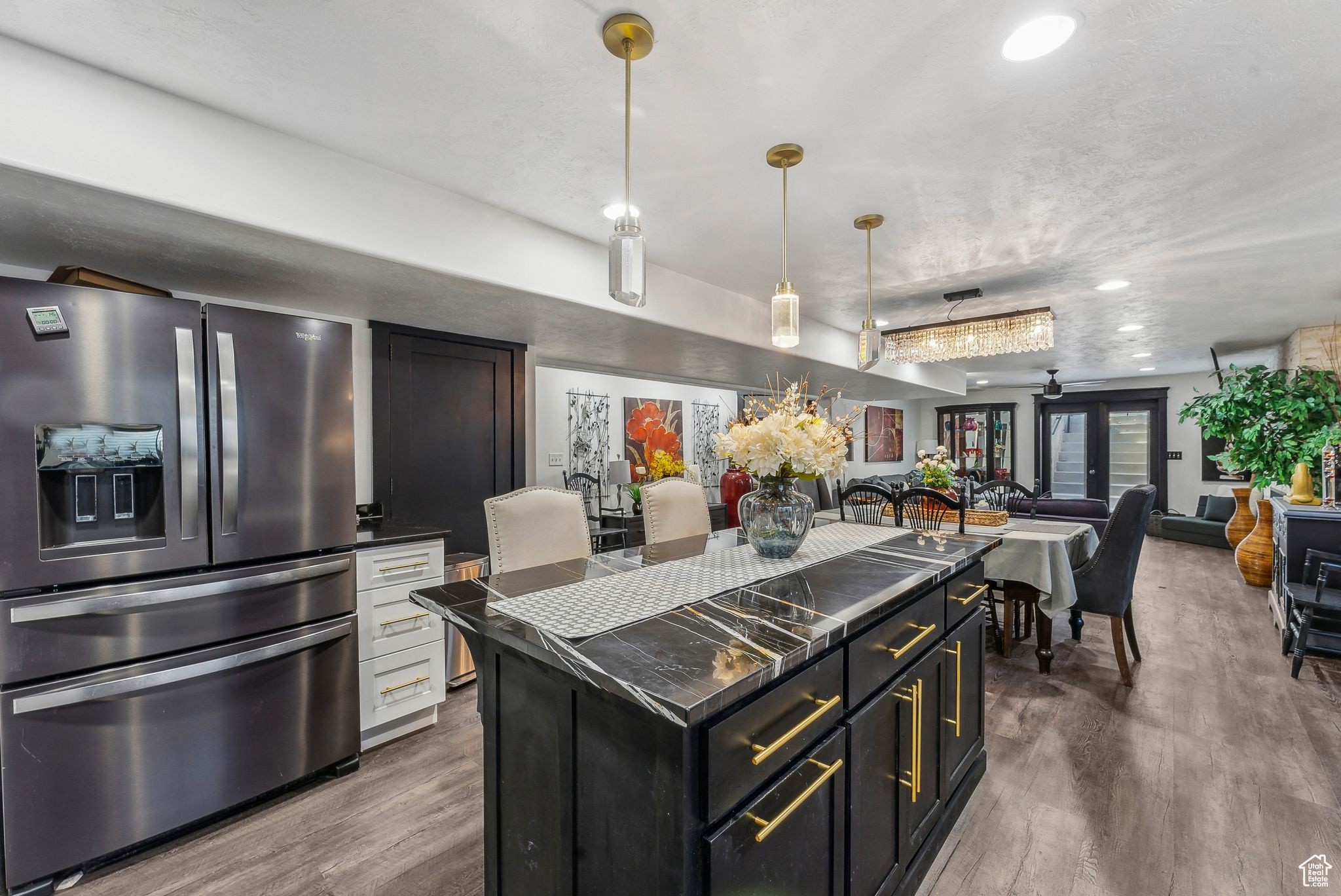 Kitchen with a center island, pendant lighting, dark hardwood / wood-style floors, and stainless steel fridge