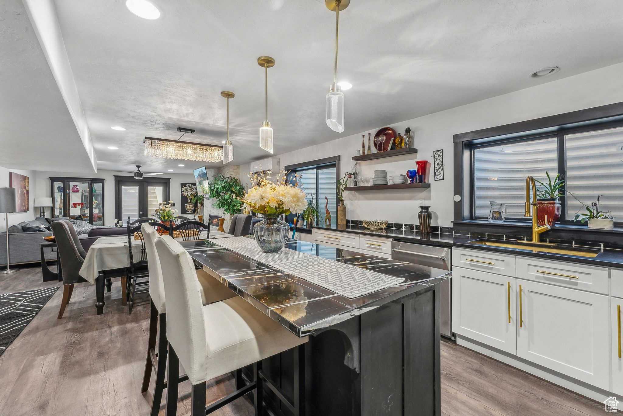 Kitchen featuring a breakfast bar area, white cabinets, pendant lighting, light hardwood / wood-style floors, and a kitchen island