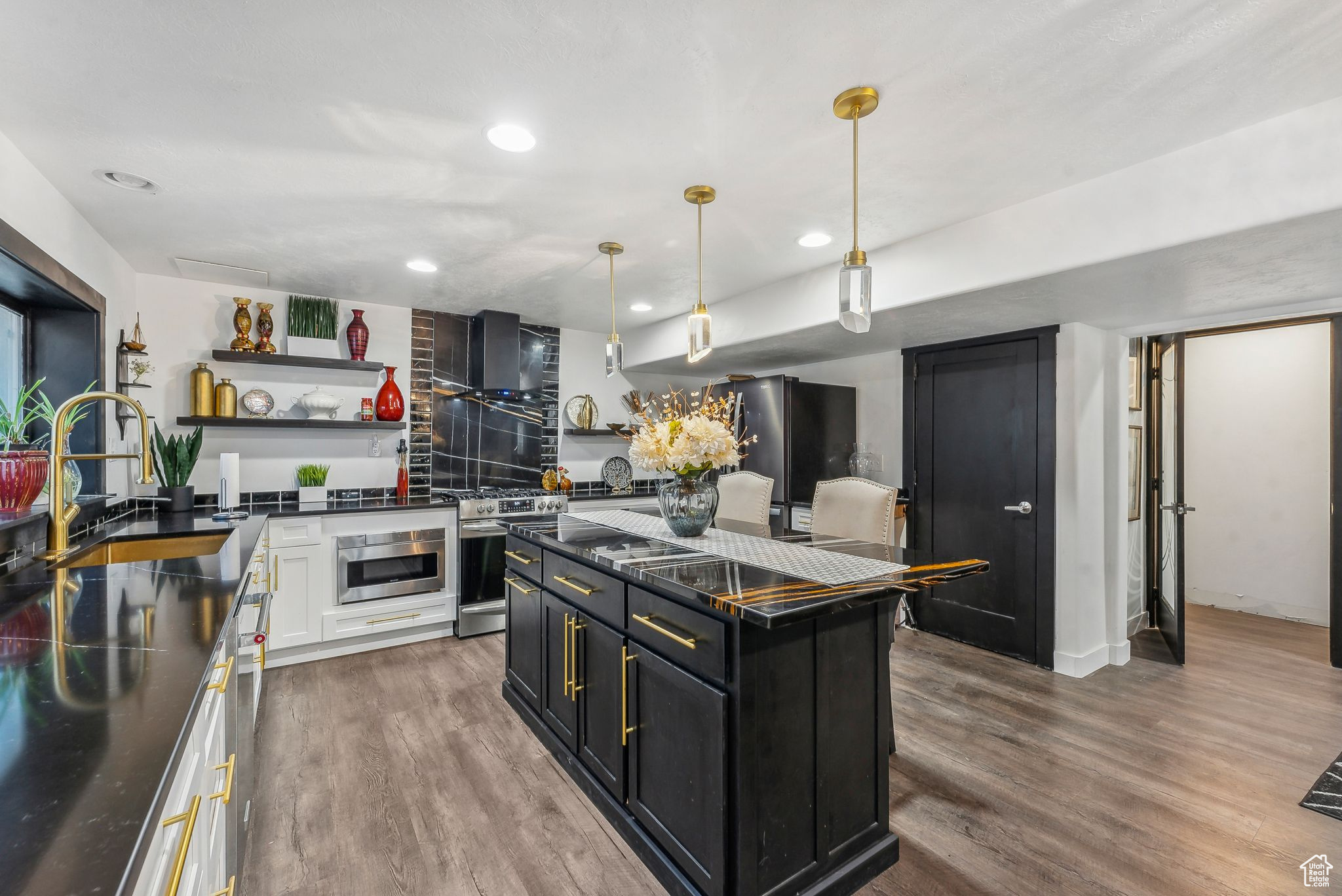 Kitchen featuring white cabinets, stainless steel appliances, a center island, and hardwood / wood-style floors