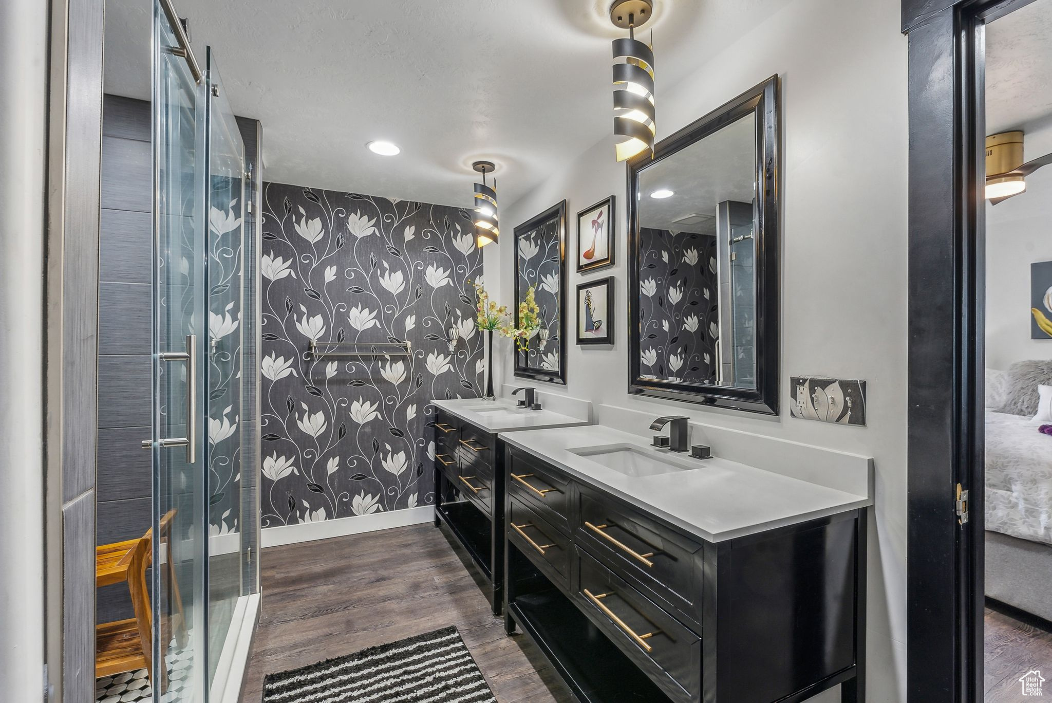 Bathroom featuring double sink vanity, hardwood / wood-style floors, and an enclosed shower